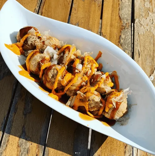Takoyaki with a spicy drizzle, in a long white dish